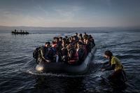 FILE -- A volunteer directs a boat of migrants as they arrive on the island of Lesbos, Greece, Oct. 15, 2015. The trial of two dozen aid workers on charges of espionage for helping migrants arriving in Greece has begun in January 2023. Amnesty International has called the case Òfarcical.Ó (Sergey Ponomarev/The New York Times) 