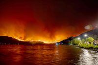 (FILES) Residents watch the McDougall Creek wildfire in West Kelowna, British Columbia, Canada, on August 17, 2023, from Kelowna. Human-caused climate change made 2023's severe, months-long "fire weather" conditions that drove Canada's record-breaking blazes at least seven times more likely to happen, according to a new scientific analysis published on August 22, 2023. The study by the World Weather Attribution group also found that over the year, fire-prone conditions were 50 percent more intense as a result of global warming, primarily a result of burning fossil fuels. (Photo by Darren HULL / AFP) (Photo by DARREN HULL/AFP via Getty Images)