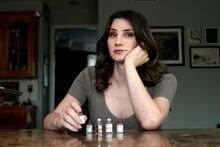Transgender woman Stacy Cay displays some of the hormone therapy drugs she has stockpiled in fear of losing her supply, Thursday, April 20, 2023, at her home in Overland Park, Kan. (AP Photo/Charlie Riedel)