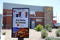 FILE - In this April 20, 2020 file photo, a new sign lets drive-thru customers know that the available menu at a local McDonalds is no longer complete due to the ongoing coronavirus restrictions in Phoenix. Most McDonalds restaurants in the U.S. and China are now open for drive-thru and delivery, but global lockdown orders still took a bite out of the companys first-quarter sales. McDonalds said Thursday, April 30,  its sales fell 6% to $4.71 billion in the January-March period. (AP Photo/Ross D. Franklin, File)
