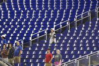 FILE - Baseball fans stand during the singing of the National Anthem before the start of a baseball game between the Miami Marlins and the Texas Rangers, Thursday, July 21, 2022, in Miami. Major League Baseball teams head into the final months of the regular season struggling to fill the stands now, even without pandemic-related attendance restrictions. (AP Photo/Wilfredo Lee, File)