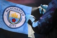FILE PHOTO: Soccer Football - Premier League - Manchester City v Liverpool - Etihad Stadium, Manchester, Britain - July 2, 2020 A staff member disinfects the corner flag, as play resumes behind closed doors following the outbreak of the coronavirus disease (COVID-19) Laurence Griffiths/Pool via REUTERS