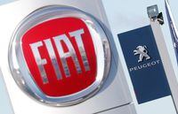 FILE PHOTO: The logos of car manufacturers Fiat and Peugeot are seen in front of dealerships of the companies in Saint-Nazaire, France, November 8, 2019. REUTERS/Stephane Mahe