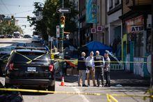 A member of the Independent Investigations Office (IIO) speaks to other investigators at the scene of a police involved shooting in the Downtown Eastside of Vancouver, on Saturday, July 30, 2022. THE CANADIAN PRESS/Darryl Dyck