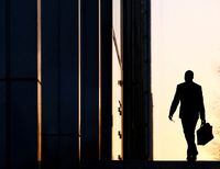 A worker arrives at his office in the Canary Wharf business district in London Feb. 26, 2014.