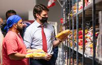 Prime Minister Justin Trudeau looks at some of the food that will be given away during a visit to the Guru Nanak Food Bank in Surrey, B.C. on Tuesday May 24, 2022. THE CANADIAN PRESS/Rich Lam