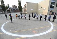 Children wait in a physical distancing circle at Portage Trail Community School, which is part of the Toronto District School Board (TDSB), during the COVID-19 pandemic in Toronto on Tuesday, Sept. 15, 2020. THE CANADIAN PRESS/Nathan Denette