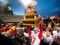 Laval Rouge et Or's Aleck Brodeur hoists the Vanier Cup after defeating the Calgary Dinos in Hamilton on Nov. 26, 2016.