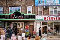 People walk past a grocery store in the Borough Park neighborhood of Brooklyn, on Oct. 8, 2020.