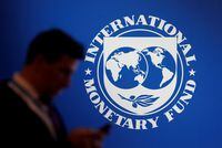 FILE PHOTO: A participant stands near a logo of IMF at the International Monetary Fund - World Bank Annual Meeting 2018 in Nusa Dua, Bali, Indonesia, October 12, 2018. REUTERS/Johannes P. Christo/File Photo