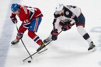 Montreal Canadiens left wing Rafael Harvey-Pinard (49) and Columbus Blue Jackets right wing Kirill Marchenko (86) battle for the puck during third period NHL hockey action in Montreal Saturday, March 25, 2023. THE CANADIAN PRESS/Peter McCabe