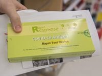 A man displays his COVID-19 rapid test kit after receiving it at a pharmacy in Montreal, Monday, Dec. 20, 2021, as the COVID-19 pandemic continues in Canada and around the world. THE CANADIAN PRESS/Graham Hughes