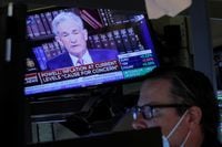 A screen shows Federal Reserve Chair Jerome Powell speak as a trader works inside a post on the floor of the New York Stock Exchange (NYSE) in New York City, U.S., August 27, 2021.  REUTERS/Brendan McDermid