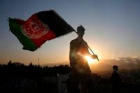 FILE - In this Aug. 19, 2019, file photo, a man waves an Afghan flag during Independence Day celebrations in Kabul, Afghanistan. Officials on both sides of Afghanistan's protracted conflict say efforts are ramping up for the start of intra-Afghan negotiations, a critical next step to a U.S. negotiated peace deal with the Taliban. (AP Photo/Rafiq Maqbool, File)