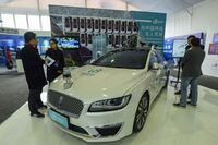 This photo taken on January 20, 2019 shows visitors looking at a driverless car with 5G technology by WeRide at a 5G innovation park in Hangzhou in China's eastern Zhejiang province.