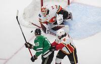 Calgary Flames goalie Cam Talbot (39) makes the save on Dallas Stars' Corey Perry (10) as Flames' Rasmus Andersson (4) defends during first period NHL Western Conference Stanley Cup playoff action in Edmonton, Tuesday, Aug. 18, 2020. THE CANADIAN PRESS/Jason Franson