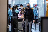 FILE PHOTO: Passengers wait to be tested after they arrive at Toronto's Pearson airport after mandatory coronavirus disease (COVID-19) testing took effect for international arrivals in Mississauga, Ontario, Canada February 15, 2021. REUTERS/Carlos Osorio/File Photo