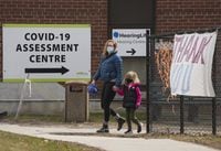 People walk past a COVID-19 assessment centre outside a hospital in Toronto on Monday, April 4, 2022. Ontario is able to manage the "little spike" in COVID-19 that the province is seeing right now, Premier Doug Ford said Monday, as hospitalizations jumped 30 per cent week over week.THE CANADIAN PRESS/Nathan Denette