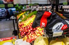 A couple walk in the produce aisle as a netted bag is seen up for sale the IGA supermarket in Saint-Leonard in Montreal, Que on Dec. 10, 2019.