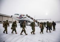 Eighty soldiers from across 3rd Canadian Division board a plane while deploying to Poland to join the lead elements already in that country as part of the Government of Canada's response to the war in Ukraine, in Edmonton, Friday April 15, 2022. THE CANADIAN PRESS/Jason Franson 