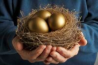 Senior Citizen holding three golden eggs in a bird's nest.