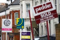 FILE PHOTO: Estate agents boards are lined up outside houses in south London June 3, 2014. REUTERS/Andrew Winning