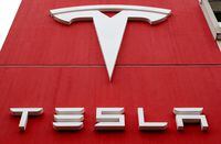FILE PHOTO: The logo of car manufacturer Tesla is seen at a branch office in Bern, Switzerland October 28, 2020. REUTERS/Arnd Wiegmann/File Photo
