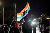 Protesters chant and wave flags in front of the Multnomah County Sheriff's Office on Aug. 11, 2020, in Portland, Ore.