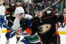 Vancouver Canucks defenseman Akito Hirose, left, hits Anaheim Ducks right wing Troy Terry with his stick during the third period of an NHL hockey game Tuesday, April 11, 2023, in Anaheim, Calif. (AP Photo/Mark J. Terrill)