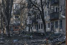 A local resident runs past the damaged houses in Bakhmut, the site of heavy battles with Russian troops in the Donetsk region, Ukraine, Sunday, Apr. 9, 2023. (AP Photo/Libkos)
