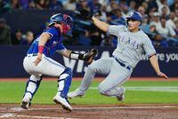 Texas Rangers' Corey Seager (right) scores ahead of the tag from Toronto Blue Jays catcher Tyler Heineman (55) during sixth inning American League MLB baseball action in Toronto on Tuesday, September 12, 2023. THE CANADIAN PRESS/Nathan Denette