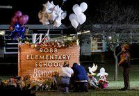 FILE PHOTO: Stephanie and Michael Chavez of San Antonio pay their respects at a makeshift memorial outside Robb Elementary School, the site of a mass shooting, in Uvalde, Texas, U.S., May 25, 2022. REUTERS/Nuri Vallbona//File Photo