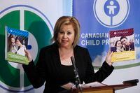 Lianna McDonald, Executive Director of the Canadian Centre for Child Protection, holds text books as she speaks at a press conference at the Canadian Centre for Child Protection in Winnipeg Wednesday, October 1, 2014. McDonald, executive director of the Canadian Centre for Child Protection, was among a dozen people appointed last week to the expert panel asked to help the government craft a new online safety bill. THE CANADIAN PRESS/John Woods