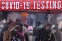 FILE PHOTO: People queue to be tested for COVID-19 in Times Square, as the Omicron coronavirus variant continues to spread in Manhattan, New York City, U.S., December 20, 2021. REUTERS/Andrew Kelly/File Photo