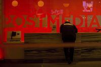 A security guard stands by the front reception desk at Postmedia's Toronto headquarters on Monday, March 12, 2018. THE CANADIAN PRESS/Chris Young