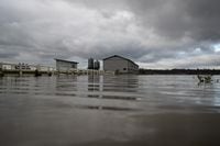 A barn on high ground is seen with receded floodwaters still surrounding it on a farm in Abbotsford, B.C., on Tuesday, November 23, 2021. THE CANADIAN PRESS/Darryl Dyck