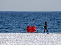 A woman walks along the snow covered beach in the evening sun in Toronto, in 2022. Canadians are worried about the rising inflation rates, THE CANADIAN PRESS/Frank Gunn