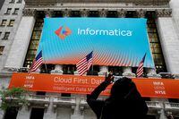 A woman photographs a banner celebrating the Informatica IPO on the front of the New York Stock Exchange (NYSE) in New York City, U.S., October 27, 2021.  REUTERS/Brendan McDermid