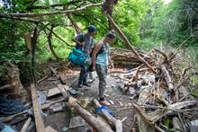 Austin Bates and Christeen Thornton examine a homeless camp in Oshawa, Ont. on June 22, 2018.