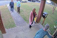 FILE - In this image taken from Coffee County, Ga., security video, Cathy Latham, bottom, chair of the Coffee County Republican Party, greets a team of computer experts from data solutions company SullivanStrickler at the county elections office in Douglas, Ga., on Jan. 7, 2021. Lawyers investigating a breach of voting system data that potentially has put Georgia’s election system at risk are asking a judge to order former Republican Party chair Latham to turn over data from her personal devices, which they say could help determine what happened to the breached data and who orchestrated the scheme. (Coffee County via AP, File)