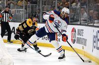 BOSTON, MASSACHUSETTS - MARCH 09: Darnell Nurse #25 of the Edmonton Oilers clears the puck past Tyler Bertuzzi #59 of the Boston Bruins during the first period at TD Garden on March 09, 2023 in Boston, Massachusetts. (Photo by Maddie Meyer/Getty Images)