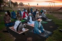 A small group of Muslim clerics pray before looking for the crescent moon which will signal the start of the month of Ramadan, in Seapoint on April 23, 2020, in Cape Town.