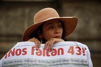 FILE - A woman carries a banner that reads in Spanish "We are missing 43," referring to the 43 missing students from a rural teachers college during a march in Mexico City, Thursday, Nov. 26, 2015. The Truth Commission created to find out what happened to the missing students presented on Thursday, Aug. 18, 2022, a report that hints at the possible responsibility of the Mexican army in the disappearance. (AP Photo/Eduardo Verdugo, File)