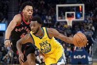 Golden State Warriors forward Andrew Wiggins (22) dribbles the basketball against Toronto Raptors forward Scottie Barnes (4) during the third quarter at Chase Center in San Francisco on Nov. 21, 2021.