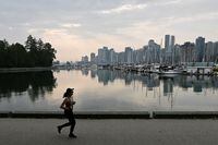 A woman runs along the seawall as an air quality warning for Vancouver has been extended as wildfires contribute to poor air quality, in Vancouver, British Columbia, Canada, September 12, 2022.  REUTERS/Jennifer Gauthier