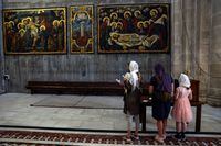 People view paintings during a visit to the Church of the Holy Sepulchre, in Jerusalem's Old City, April 11, 2022. Picture taken April 11, 2022. REUTERS/Ronen Zvulun