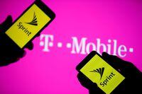 FILE PHOTO: A smartphones with Sprint logo are seen in front of a screen projection of T-mobile logo, in this picture illustration taken April 30, 2018. REUTERS/Dado Ruvic/Illustration/File Photo