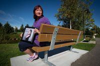 Carol Todd holds a photograph of her late daughter Amanda Todd while sitting on a bench dedicated to her at Settlers Park in Port Coquitlam, B.C., on Sunday October 5, 2013. Todd says police need to take online harassment seriously and not shame victims into thinking they brought their torment on themselves.THE CANADIAN PRESS/Darryl Dyck
