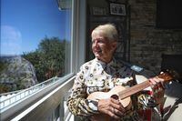 Doreen Smith plays the ukulele at her Kelowna, B.C., home on Aug. 2, 2023. (Aaron Hemens/The Globe and Mail)