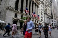In this file photo taken on July 12, people walk past the New York Stock Exchange (NYSE) on Wall Street in New York City.